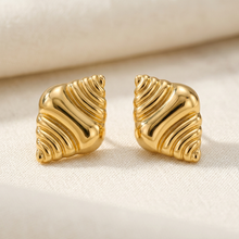 Brinco Maré Dourado em aço inoxidável com design de ondas.