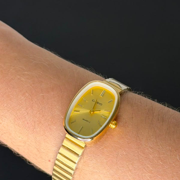 Relógio Vintage Oval Dourado Aço Inoxidável com mostrador dourado e pulseira ajustável.