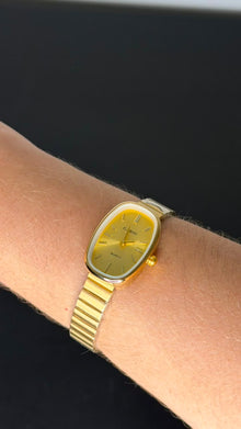 Relógio Vintage Oval Dourado Aço Inoxidável com mostrador dourado e pulseira ajustável.