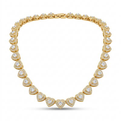 Close-up de um colar riviera dourado com elos em formato de coração cravejados com pedras brilhantes, exibido em um busto de joalheria branco.
