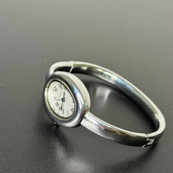 Relógio bracelete oval prata em aço inox com mostrador analógico e algarismos romanos.