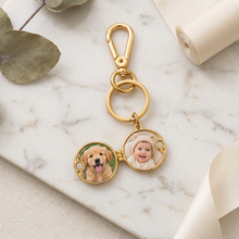 Chaveiro relicário redondo dourado com fotos de um cachorro e um bebê.