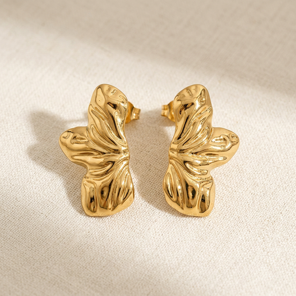 Brinco Flor Orgânico Dourado Aço Inoxidável da Amba Black em orelha de modelo.