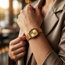 Relógio quadrado dourado com pulseira de aço inoxidável.