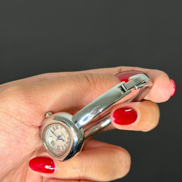 Relógio bracelete oval prata em aço inox com mostrador analógico e algarismos romanos.