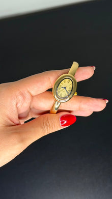 Relógio bracelete oval dourado com mostrador analógico da Amba Black.