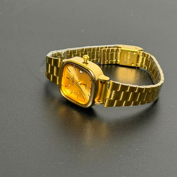 Relógio quadrado dourado com pulseira de aço inoxidável.