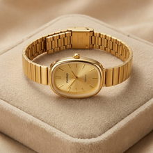 Relógio Vintage Oval Dourado Aço Inoxidável com mostrador dourado e pulseira ajustável.