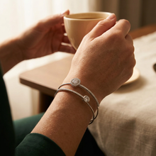 Bracelete aro duplo com zircônias em prata folheada em uma caixa de joias.