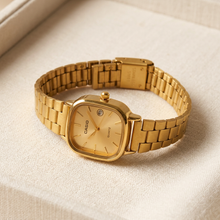 Relógio quadrado dourado com pulseira de aço inoxidável.