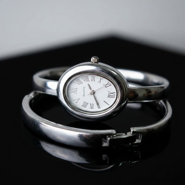Relógio bracelete oval prata em aço inox com mostrador analógico e algarismos romanos.