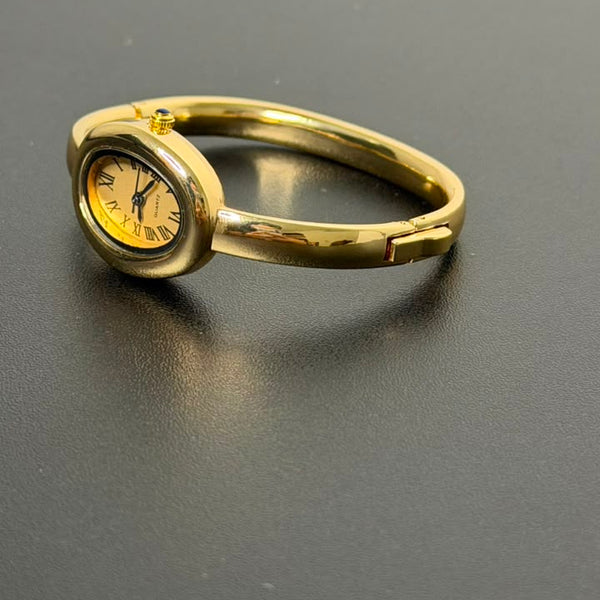 Relógio bracelete oval dourado com mostrador analógico da Amba Black.