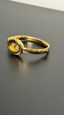 Relógio bracelete oval dourado com mostrador analógico da Amba Black.