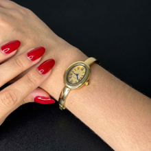 Relógio bracelete oval dourado com mostrador analógico da Amba Black.