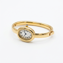 Relógio bracelete oval dourado com mostrador branco e números romanos.