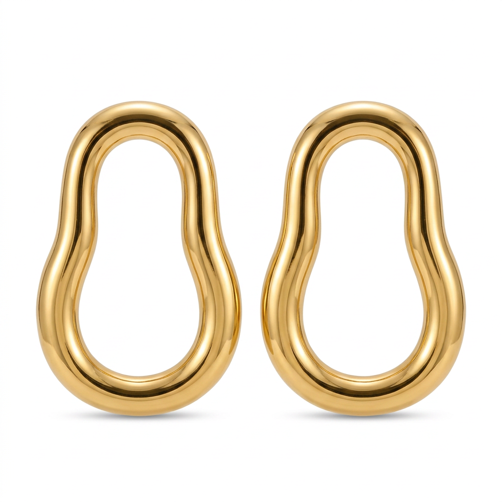 Brinco orgânico dourado em aço inoxidável sobre teclado.