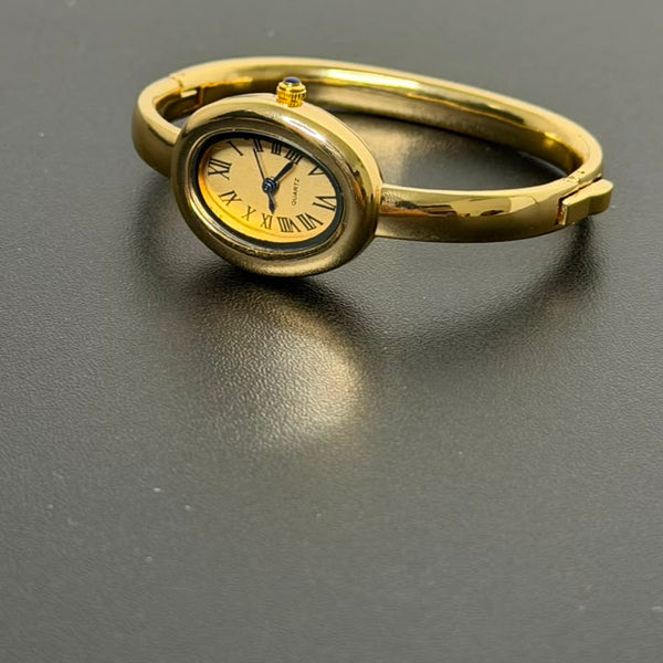 Relógio bracelete oval dourado com mostrador analógico da Amba Black.
