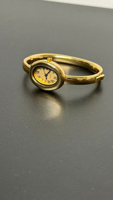 Relógio bracelete oval dourado com mostrador analógico da Amba Black.