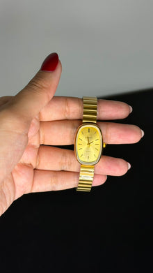 Relógio Vintage Oval Dourado Aço Inoxidável com mostrador dourado e pulseira ajustável.