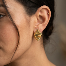 Brinco Maré Dourado em aço inoxidável com design de ondas.