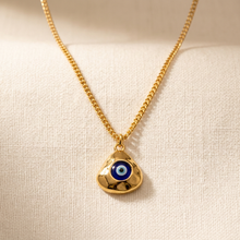 Colar com pingente de olho grego dourado em manequim.