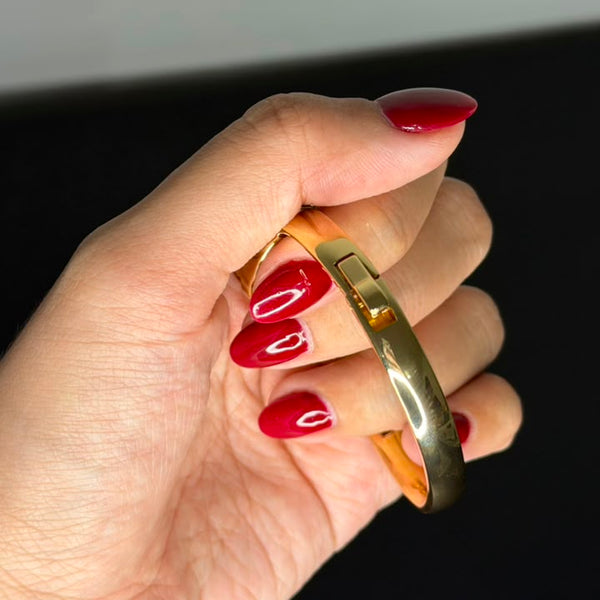 Relógio bracelete oval dourado com mostrador analógico da Amba Black.