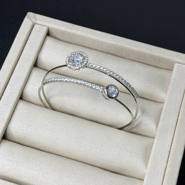 Bracelete aro duplo com zircônias em prata folheada em uma caixa de joias.