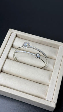 Bracelete aro duplo com zircônias em prata folheada em uma caixa de joias.
